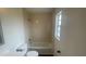 Bathroom with a tiled tub surround and a bright window at 4 Pine Pass Ter, Ocala, FL 34472