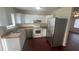 Cozy kitchen featuring bright white cabinets, stainless steel appliances and wood floor at 4 Pine Pass Ter, Ocala, FL 34472