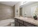 Bathroom featuring tile floors, a large vanity with dark wood cabinets, a tile backsplash, and a shower-tub combo at 476 Marion Oaks Pass, Ocala, FL 34473