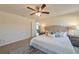 Comfortable bedroom with neutral tones, carpet flooring, ceiling fan, and views to living room at 476 Marion Oaks Pass, Ocala, FL 34473