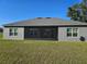 Rear exterior view showing a screened patio, gray siding, and a well-maintained lawn at 4838 Sw 130Th St, Ocala, FL 34473