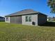 Exterior view of home featuring gray stucco siding, black roof, screened-in patio, and green lawn at 4838 Sw 130Th St, Ocala, FL 34473