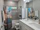 Modern bathroom with double sinks, gray tile, and a shower-tub combo at 4838 Sw 130Th St, Ocala, FL 34473