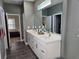 Bathroom featuring a double vanity with white countertops and sleek gray walls at 4838 Sw 130Th St, Ocala, FL 34473