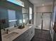 Bright bathroom featuring double vanity with white countertop and walk-in shower with glass door at 4838 Sw 130Th St, Ocala, FL 34473