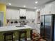 A contemporary kitchen with white cabinets, stainless steel appliances, and a spacious island with seating at 4838 Sw 130Th St, Ocala, FL 34473