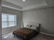 A bright bedroom featuring a decorative tray ceiling, neutral tones and a plush carpet at 4838 Sw 130Th St, Ocala, FL 34473