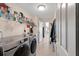 Functional laundry area with modern washer and dryer units, storage shelves, and easy access to the home at 5040 Nw 35Th St, Ocala, FL 34482