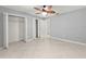 A bedroom featuring tiled floors, an open closet, neutral paint, and a ceiling fan at 5906 Sw 108Th St, Ocala, FL 34476