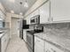 Bright kitchen features stainless steel appliances, granite countertops, and white cabinets at 5906 Sw 108Th St, Ocala, FL 34476