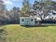 Backyard view of a well-kept storage shed with painted wooden doors on a grassy lawn at 5906 Sw 108Th St, Ocala, FL 34476