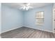 Bright bedroom with a ceiling fan, light blue walls, and attractive wood-look flooring at 644 Sw 2Nd St, Ocala, FL 34471