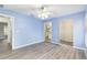 Bright bedroom with blue walls, wood-look floors, ceiling fan, and ensuite bathroom access at 644 Sw 2Nd St, Ocala, FL 34471