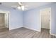 Bedroom featuring wood-look flooring, light-blue walls, and access to both the bathroom and closet at 644 Sw 2Nd St, Ocala, FL 34471