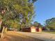 Single-story home with a long driveway, garage, large tree, and covered area perfect for gatherings at 6611 Sw 80Th Ave, Ocala, FL 34481