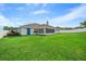 Expansive backyard with lush green lawn, screened in porch, and partial fencing at 6875 Se 11Th Pl, Ocala, FL 34472