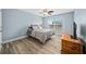 Bedroom featuring wood floors, neutral walls, large window and a wood dresser at 6875 Se 11Th Pl, Ocala, FL 34472