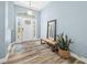 Inviting foyer with wood-look floors, a neutral rug, a decorative mirror, and bright natural light at 6875 Se 11Th Pl, Ocala, FL 34472