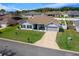 Well-maintained single-story home featuring a gray exterior, a two-car garage, and a green lawn at 6875 Se 11Th Pl, Ocala, FL 34472