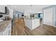 Modern kitchen featuring an island, wood-look floors, sleek white cabinetry, and stainless steel appliances at 6875 Se 11Th Pl, Ocala, FL 34472