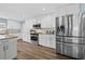 Bright kitchen featuring stainless steel appliances, granite countertops, and sleek white cabinetry at 6875 Se 11Th Pl, Ocala, FL 34472
