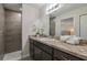 Bathroom featuring walk-in shower with tile surround, granite countertop and a large mirror at 7772 Sw 146Th Lane Rd, Ocala, FL 34473