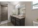 Bathroom with granite countertop, modern fixtures, walk-in shower and large mirror at 7772 Sw 146Th Lane Rd, Ocala, FL 34473