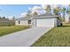 Charming single-story home featuring a well-manicured lawn and concrete driveway leading to the garage at 7772 Sw 146Th Lane Rd, Ocala, FL 34473
