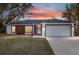 Beautiful single-story home featuring a well-manicured lawn under a colorful sunset sky at 800 Marion Oaks Mnr, Ocala, FL 34473