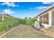 Backyard with green lawn, lush hedges, a small garden, and a screened-in patio at 8245 Sw 78Th Terrace Rd, Ocala, FL 34476