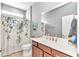 Well-lit bathroom featuring a single sink vanity and shower with floral curtain at 8245 Sw 78Th Terrace Rd, Ocala, FL 34476