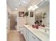 Well-lit bathroom with a double vanity, large mirror, and a glass-enclosed shower at 8670 Sw 88Th Pl, Ocala, FL 34481