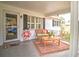 Inviting front porch with wicker bench, welcome sign, and small coffee table at 8888 Sw 95Th Ln # D, Ocala, FL 34481