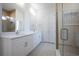 Elegant bathroom features a double sink vanity, neutral tones and a glass shower with a tiled accent wall at 9594 Se 61St Ter, Belleview, FL 34420
