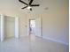 Bright, open bedroom featuring marble floors, a ceiling fan, and an attached closet at 9594 Se 61St Ter, Belleview, FL 34420