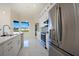 Modern kitchen with stainless steel appliances, white cabinetry, and marble floors with a large window view at 9594 Se 61St Ter, Belleview, FL 34420