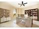 Well-lit home office boasts built-in shelving, a glass desk, and stylish decor for a productive workspace at 9594 Se 61St Ter, Belleview, FL 34420