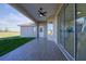 Covered outdoor patio area with tile flooring, ceiling fan, and sliding glass doors at 9594 Se 61St Ter, Belleview, FL 34420