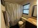 Bathroom featuring a shower/tub, toilet, dark vanity, towel bar, window, and mirror at 1008 Se 26Th St, Ocala, FL 34471