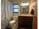 Bathroom featuring a toilet, sink, vanity, shower with patterned curtain, and window at 1008 Se 26Th St, Ocala, FL 34471