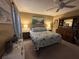 Comfortable bedroom with a ceiling fan, lamps, and matching dressers with a coastal inspired comforter at 1008 Se 26Th St, Ocala, FL 34471