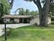 Single story home features a large front yard, mature trees, a lamp post, and long driveway at 1008 Se 26Th St, Ocala, FL 34471