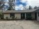 Charming single-story home featuring a front oval door, brown shutters and mature landscaping at 1008 Se 26Th St, Ocala, FL 34471