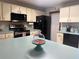 Traditional kitchen with dated wallpaper, an island, and black appliances at 1008 Se 26Th St, Ocala, FL 34471