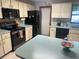 Traditional kitchen with an island, black appliances, and dated wallpaper at 1008 Se 26Th St, Ocala, FL 34471