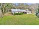 Aerial view of the home with a metal roof, patio, and a large grassy yard at 1010 Sw 26Th St, Ocala, FL 34471