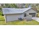 Angle view of a house with grey siding, a metal roof, an air conditioner, and a single car garage at 1010 Sw 26Th St, Ocala, FL 34471