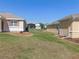 Spacious backyard featuring green grass, stone, and two homes with light-colored exteriors at 13100 Se 93Rd Terrace Rd, Summerfield, FL 34491