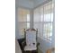 Bright bedroom corner with a rocking chair, vertical blinds, and dual windows for ample light at 13100 Se 93Rd Terrace Rd, Summerfield, FL 34491