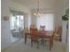 Cozy dining room featuring a wooden table set for six, with natural light and a view to sunroom at 13100 Se 93Rd Terrace Rd, Summerfield, FL 34491